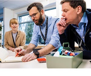 Three Associates looking at a notebook together